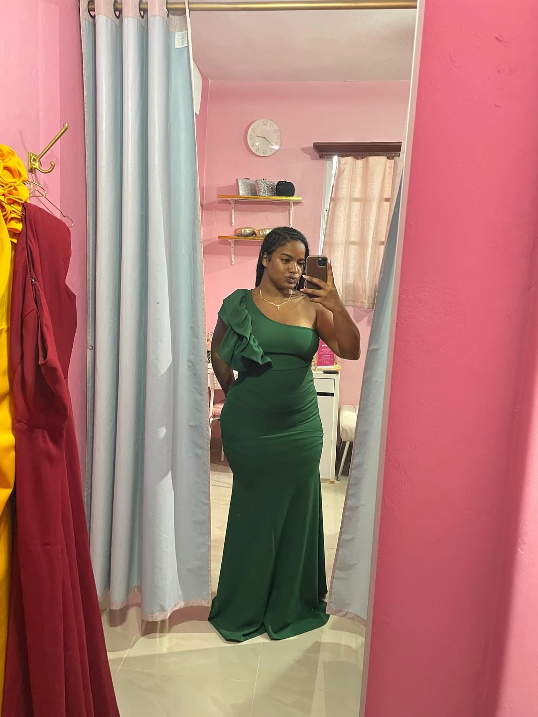 Clienta probándose un vestido verde en el probador rosado de Eversize